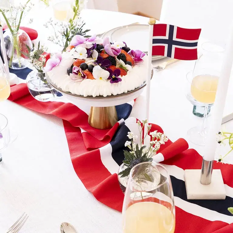 Decorate the table for May 17th with flowers and decorations in red, white, and blue